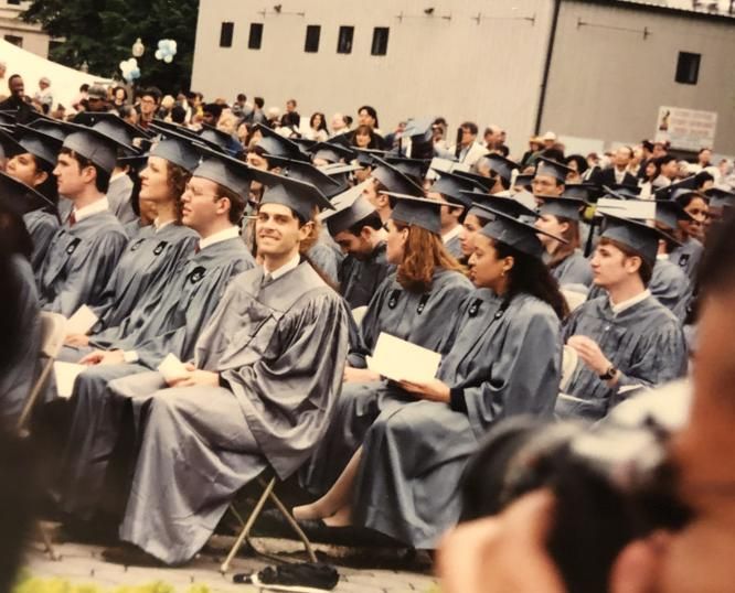 Chad seated near the center among Columbia University graduates in caps and gowns.