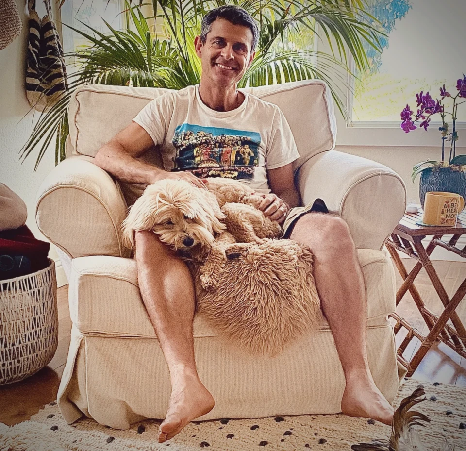 Chad relaxing in an armchair with Disco stretched across his lap.