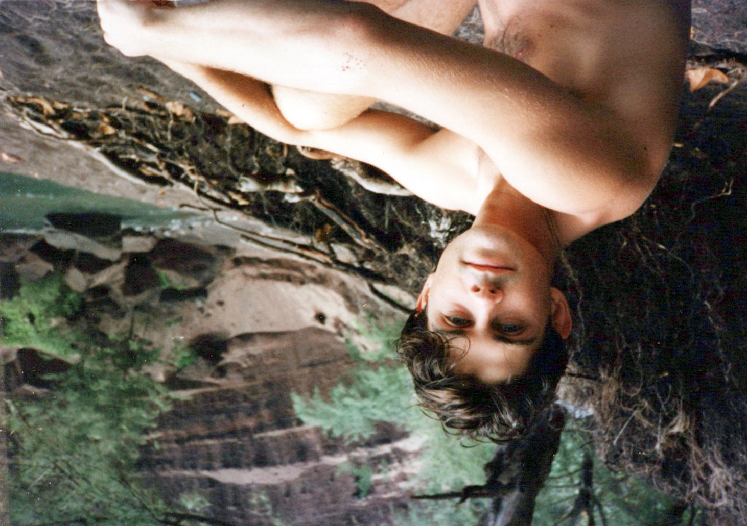 Chad sitting outdoors beside a stream in Hawaii while studying yoga.