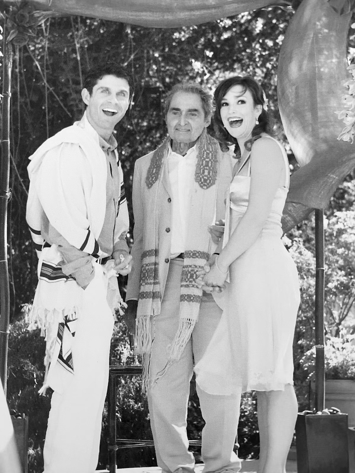 Chad and Melissa smiling with another person at their wedding.