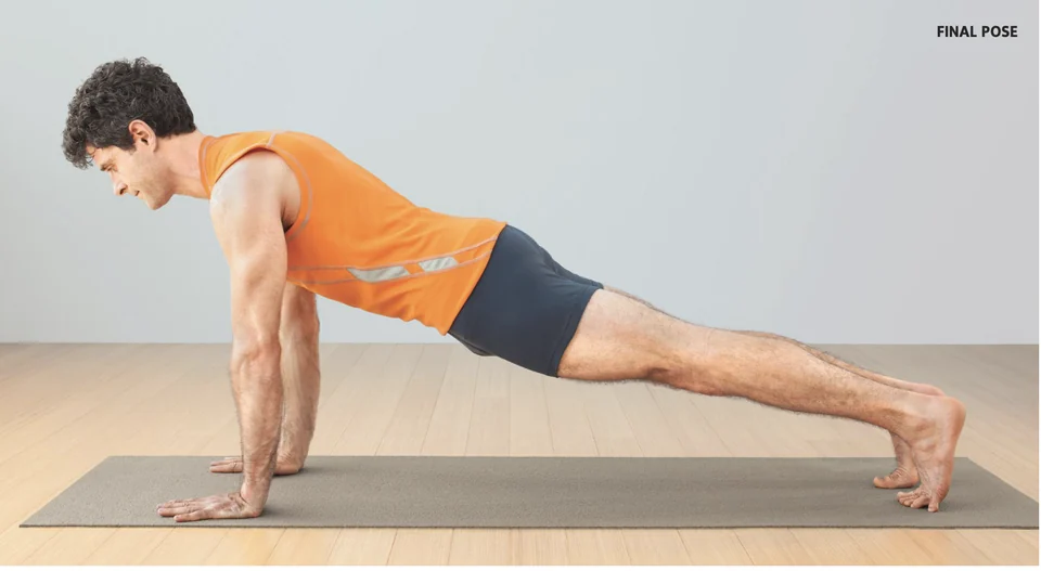 Chad holding plank pose in an orange sleeveless shirt on a yoga mat.