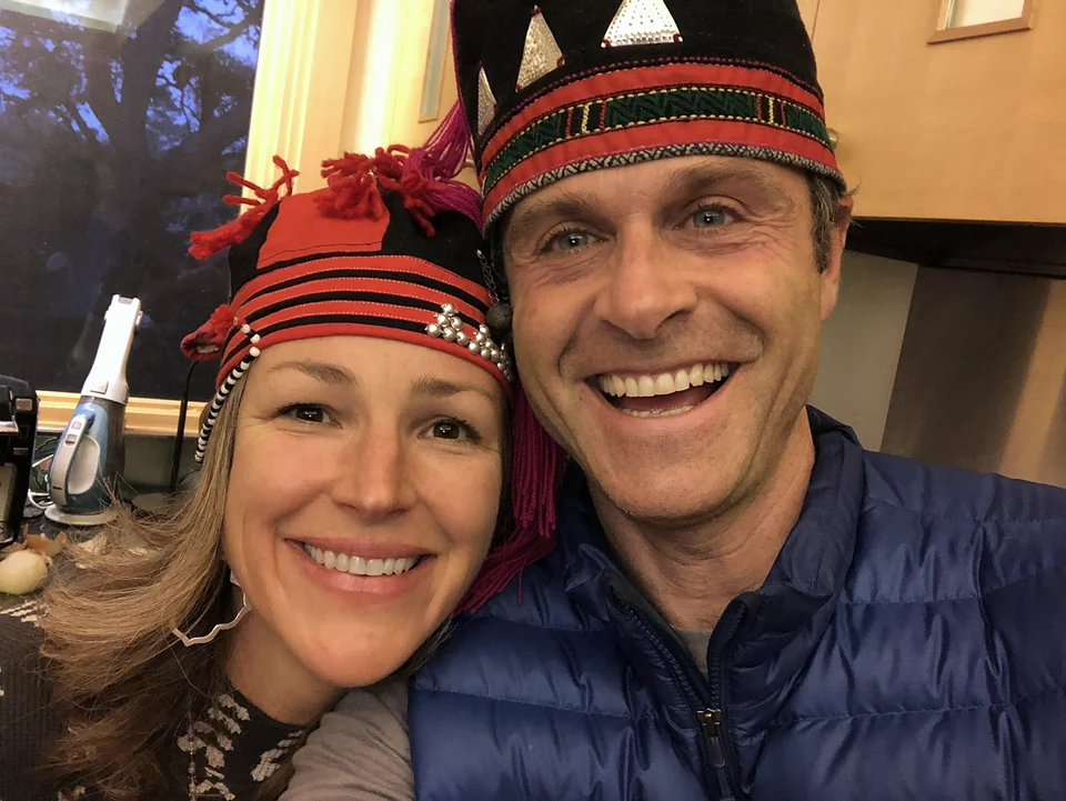 Chad and Melissa smiling together in matching red and black hats.