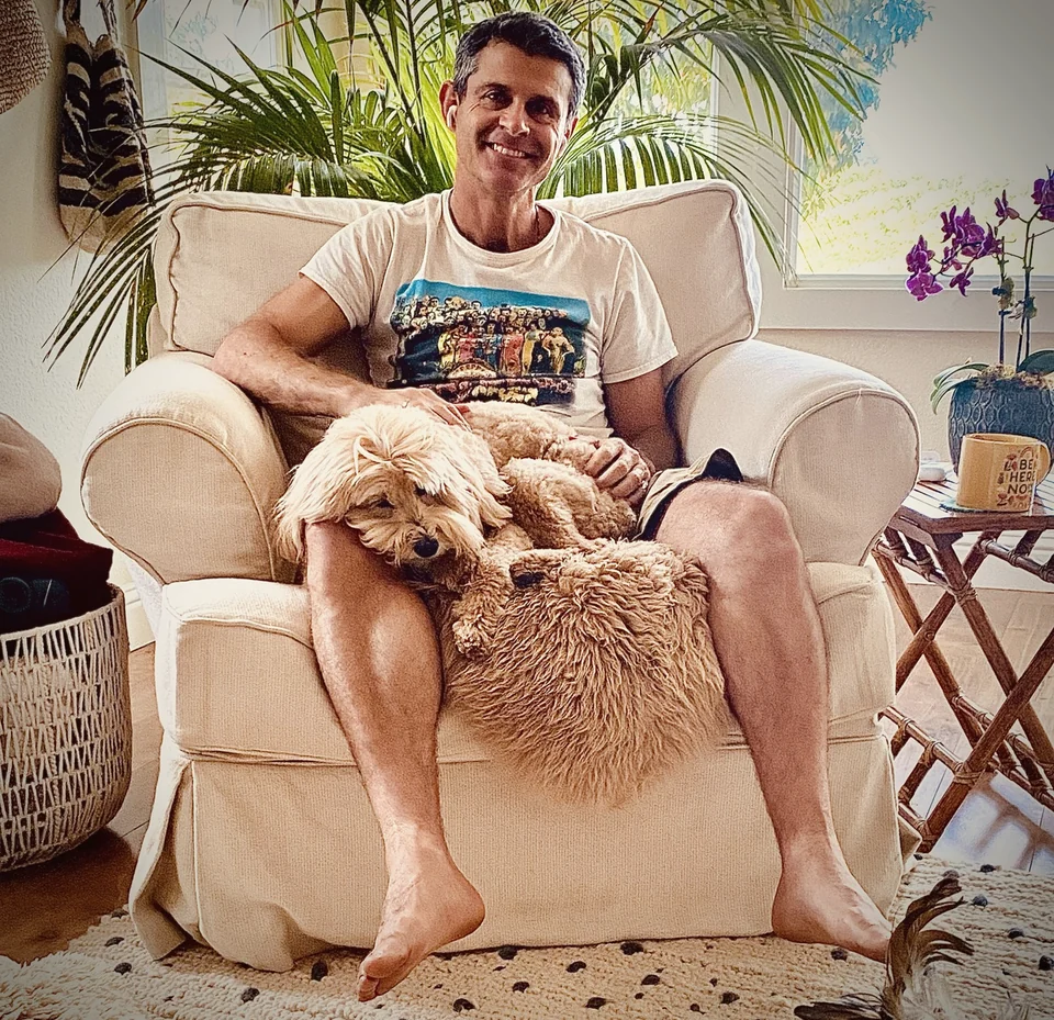 Chad relaxing in an armchair with Disco stretched across his lap.
